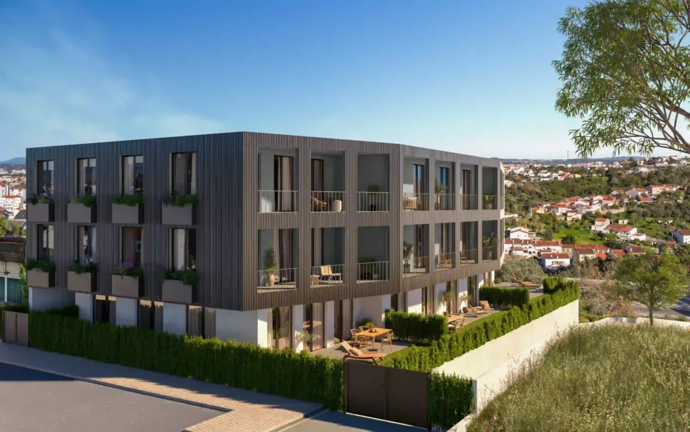 Renderização exterior, vista de ângulo, de um moderno edifício de apartamentos de três andares. A fachada é revestida com ripas escuras e tem varandas e pátios no rés-do-chão com vista para uma área urbana.